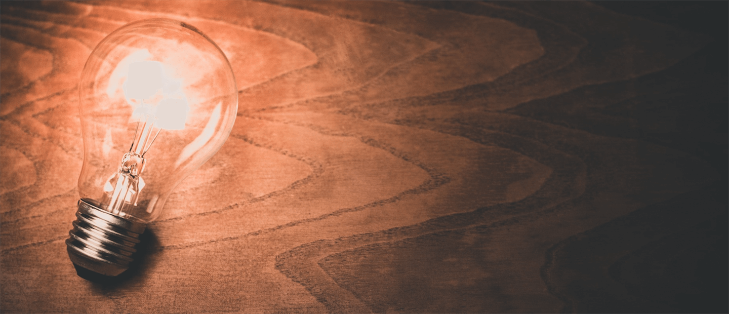 A lightbulb emitting light, laying on a desk