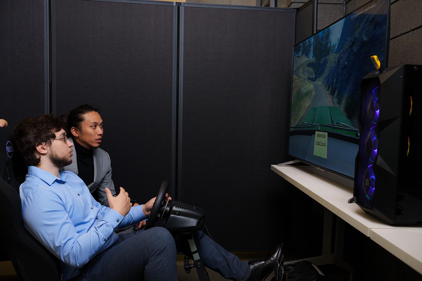 Two people using a driving simulator